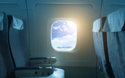 Airplane window against blue sky
